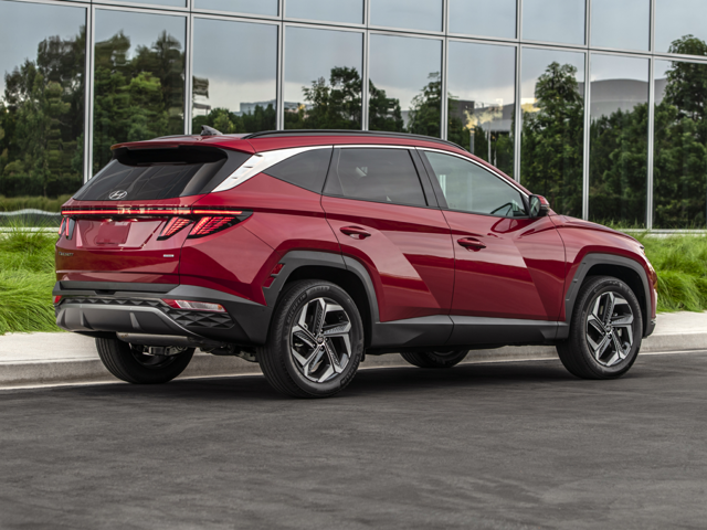 A red Hyundai Tucson parked next to a building