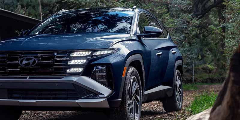 Hyundai Tucson SUV parked on forest trail near trees